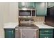 Galley kitchen featuring green cabinets and stainless steel appliances at 430 N Park Ave # 103, Indianapolis, IN 46202