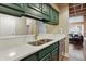Galley kitchen featuring sleek counters, stainless steel appliances, and green cabinets at 430 N Park Ave # 103, Indianapolis, IN 46202