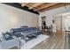 Open living room featuring exposed wood beams, unique wallpaper, and modern furnishings at 430 N Park Ave # 103, Indianapolis, IN 46202