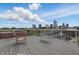 Rooftop deck featuring ample seating and stunning views of the city skyline and puffy white clouds at 430 N Park Ave # 103, Indianapolis, IN 46202