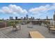 Rooftop deck featuring ample seating and stunning views of the city skyline and puffy white clouds at 430 N Park Ave # 103, Indianapolis, IN 46202