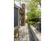 An outdoor stone walkway passes by a brick chimney in a fenced yard with landscaping at 440 Linden St, Zionsville, IN 46077