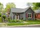 Charming bungalow with gray siding, brick chimney, well-manicured landscaping, and mature trees at 440 Linden St, Zionsville, IN 46077