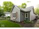 Side view of home with gray siding, red shutters, manicured lawn and pretty landscaping at 440 Linden St, Zionsville, IN 46077