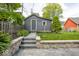 Outbuilding with a gray exterior, stone steps, and landscaping with grass in the backyard at 440 Linden St, Zionsville, IN 46077