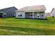 Backyard view of the home featuring a covered porch and manicured lawn at 4734 Cleome Dr, Plainfield, IN 46168