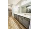 Bathroom vanity featuring double sinks, granite counters, and wood-look flooring at 4734 Cleome Dr, Plainfield, IN 46168