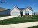 Charming front exterior with a gray garage door, manicured lawn, and sidewalk at 4734 Cleome Dr, Plainfield, IN 46168