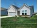 Charming one-story home featuring a well-manicured lawn, attached garage, and stylish white siding at 4734 Cleome Dr, Plainfield, IN 46168