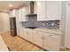 Bright kitchen featuring stainless steel appliances, tile backsplash, granite countertops, and white cabinets at 4734 Cleome Dr, Plainfield, IN 46168