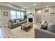 Cozy living room showcasing neutral-toned sofas, a fireplace, and natural light from large windows at 4734 Cleome Dr, Plainfield, IN 46168