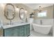 Luxurious bathroom featuring double vanity, elegant mirrors, and a freestanding soaking tub with modern fixtures at 48 E Wisteria Way, Westfield, IN 46074