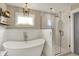 Spa-like bathroom with a modern soaking tub, a frameless glass shower, and stylish tile work at 48 E Wisteria Way, Westfield, IN 46074