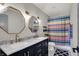 Modern bathroom featuring a double vanity with marble countertop and colorful shower curtain at 48 E Wisteria Way, Westfield, IN 46074