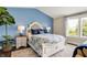 Stylish bedroom with a large bed, blue accent wall, and large windows that provide plenty of natural light at 48 E Wisteria Way, Westfield, IN 46074