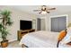 Well-lit bedroom with a large TV, a comfortable bed, a ceiling fan, and a potted plant at 48 E Wisteria Way, Westfield, IN 46074