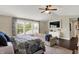 Cozy bedroom with ceiling fan, blue bedding, and a seating area with bright window at 48 E Wisteria Way, Westfield, IN 46074