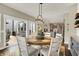 Bright dining area features a round table, modern chandelier, and sliding glass doors to the deck at 48 E Wisteria Way, Westfield, IN 46074