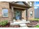 Charming covered front porch features a blue front door, stylish decor, and well-manicured landscaping at 48 E Wisteria Way, Westfield, IN 46074