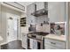 Galley kitchen featuring stainless steel oven, grey cabinetry, designer backsplash, and modern finishes at 48 E Wisteria Way, Westfield, IN 46074
