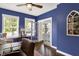 Bright office with hardwood floors, blue walls, and a ceiling fan creates a calm workspace at 48 E Wisteria Way, Westfield, IN 46074