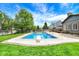 In-ground pool with diving board, patio, and green lawn against a backdrop of mature trees and a fenced yard at 48 E Wisteria Way, Westfield, IN 46074