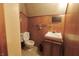 Classic bathroom with toilet, vanity, and wood paneling on the walls at 489 Highland St, Morgantown, IN 46160