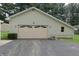 Detached garage with asphalt driveway and light fixtures at 489 Highland St, Morgantown, IN 46160