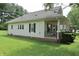 Side exterior view of the home featuring a long porch with swing and well-manicured lawn at 489 Highland St, Morgantown, IN 46160