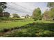 Spacious backyard with a small stream, grassy areas, and mature trees, ideal for outdoor enjoyment at 5041 Norcroft Dr, Indianapolis, IN 46221