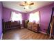 This bedroom features purple walls, wood flooring and a ceiling fan at 5041 Norcroft Dr, Indianapolis, IN 46221