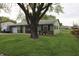 Charming single story home with a green exterior, a well-manicured lawn, and mature trees at 5041 Norcroft Dr, Indianapolis, IN 46221