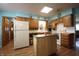Traditional kitchen featuring wood cabinets, an island, and white appliances at 5041 Norcroft Dr, Indianapolis, IN 46221
