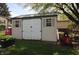 A shed with double doors and windows provides secure storage space in the backyard at 5041 Norcroft Dr, Indianapolis, IN 46221