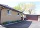 Exterior view showing the tan brick, the detached garage, and a black driveway at 518 Cherry St, Beech Grove, IN 46107