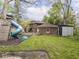 Backyard with a playground set, shed, fire pit, and a grassy area at 5181 E Pleasant Run Pkwy S Dr, Indianapolis, IN 46219