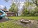 Spacious backyard with a fire pit, slide, shed, and additional storage at 5181 E Pleasant Run Pkwy S Dr, Indianapolis, IN 46219