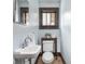 Charming powder room featuring a pedestal sink, toilet, and window at 5181 E Pleasant Run Pkwy S Dr, Indianapolis, IN 46219