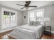Neutral bedroom featuring hardwood floors, two large windows, and a decorative lamp at 5181 E Pleasant Run Pkwy S Dr, Indianapolis, IN 46219