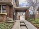Exterior of a brick home showcasing a covered driveway leading to a detached garage and landscaped surroundings at 5181 E Pleasant Run Pkwy S Dr, Indianapolis, IN 46219