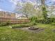 Backyard featuring a fire pit, wooden fence, and a garden at 5181 E Pleasant Run Pkwy S Dr, Indianapolis, IN 46219