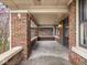 Spacious covered front porch with brick columns and a concrete floor at 5181 E Pleasant Run Pkwy S Dr, Indianapolis, IN 46219