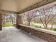 Covered front porch featuring brick accents and a view of the neighborhood street at 5181 E Pleasant Run Pkwy S Dr, Indianapolis, IN 46219