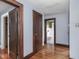 Hallway with hardwood floors, blue walls, and doorways leading to different rooms in the house at 5181 E Pleasant Run Pkwy S Dr, Indianapolis, IN 46219