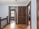 Upstairs hallway featuring hardwood floors, blue walls, and doorways leading to other rooms at 5181 E Pleasant Run Pkwy S Dr, Indianapolis, IN 46219