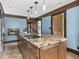 Full kitchen island with pendant lights, a sink, cooktop, and wooden cabinets at 5181 E Pleasant Run Pkwy S Dr, Indianapolis, IN 46219