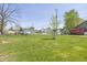 Spacious backyard with lush green grass and a young tree in the foreground at 5515 W Morris St, Indianapolis, IN 46241