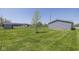 Large grassy backyard enclosed with a chainlink fence, with ample space and mature tree at 5515 W Morris St, Indianapolis, IN 46241