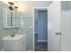 This bathroom includes a single sink vanity, medicine cabinet and view of a hallway at 5515 W Morris St, Indianapolis, IN 46241