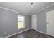 Cozy bedroom includes vinyl flooring, window view, grey walls, and modern light fixture at 5515 W Morris St, Indianapolis, IN 46241